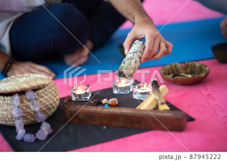 Man lighting incense stick in room 87945222
