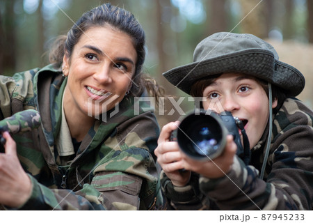 Happy family taking pictures in forest Happy family taking pictures in forest 87945233