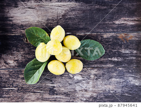 Yellow plums. Fresh ripe sweet fruits on old wooden boards rough background 87945641