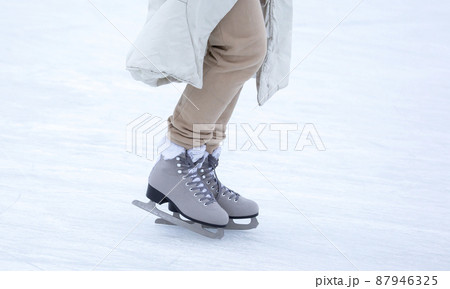 Ice skating on an ice rink. legs with skates. Winter active sport and leisure hobby. Ice skating on an ice rink. legs with skates. Winter active sport and leisure hobby. 87946325