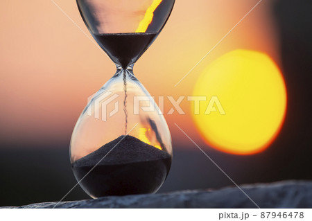Hourglass counts the length of time against the background of the evening sun Hourglass counts the length of time against the background of the evening sun 87946478