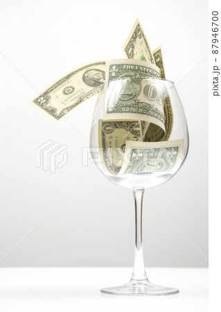 dollar banknotes money lies in an empty wine glass. business in the wine industry. alcohol marketing 87946700