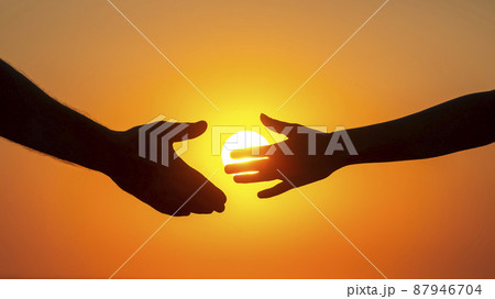 silhouette of male and female hands on the background of the setting sun. 87946704