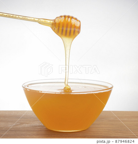 fresh fragrant honey drips from a spoon into a plate. organic vitamin nutrition. dessert food fresh fragrant honey drips from a spoon into a plate. organic vitamin nutrition. dessert food 87946824