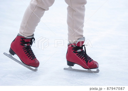 feet on skates on an ice rink. winter sport and recreation feet on skates on an ice rink. winter sport and recreation 87947087