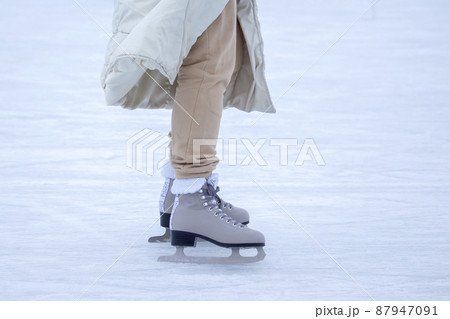 Ice skating on an ice rink. legs with skates. Winter active sport and leisure hobby. Ice skating on an ice rink. legs with skates. Winter active sport and leisure hobby. 87947091