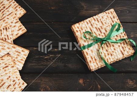 Matzah background. Happy Passover. Traditional Jewish regilious holiday Pesach. Matzo bread on a dark wooden table. Matzah background. Happy Passover. Traditional Jewish regilious holiday Pesach. Matzo bread on a dark wooden table. 87948457