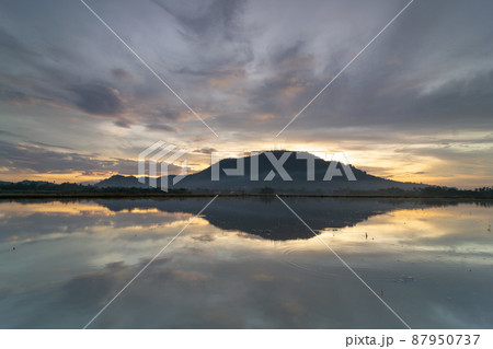 Reflection of Bukit Mertajam hill in golden dramatic sunrise 87950737