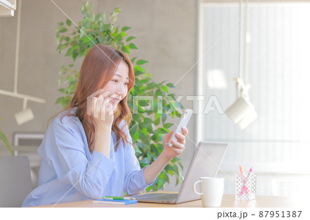 スマホを見てガッツポーズで喜ぶビジネスウーマン1 87951387