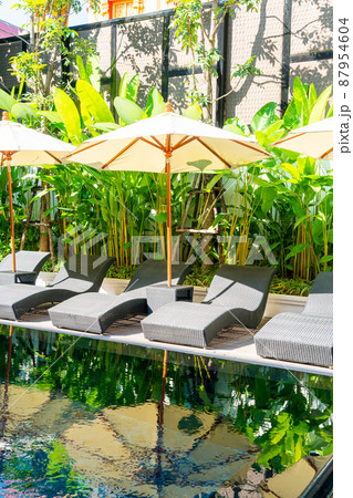 umbrella and bed pool chair around swimming pool 87954604