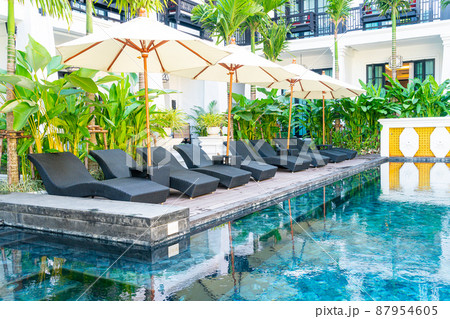 umbrella and bed pool chair around swimming pool 87954605