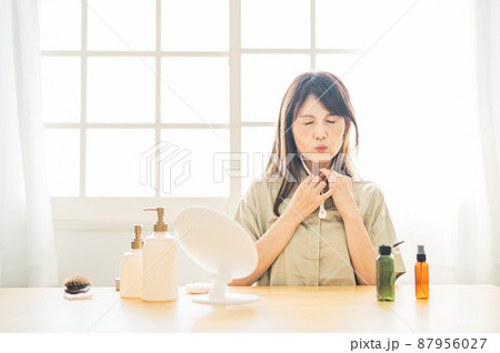 スキンケアする中高年女性(美顔ローラー・困る) スキンケアする中高年女性(美顔ローラー・困る) 87956027