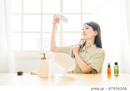 ドライヤーを使う中高年女性(笑顔) ドライヤーを使う中高年女性(笑顔) 87956208