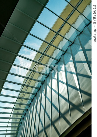 Abstract pattern of building structure of glass ceiling, light, and shadow, worm eye view image, daylight from sky, vertical image. Abstract pattern of building structure of glass ceiling, light, and shadow, worm eye view image, daylight from sky, vertical image. 87956613