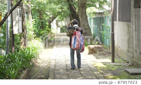 家財道具を持ち歩く男性 後ろ姿 家財道具を持ち歩く男性 後ろ姿 87957023