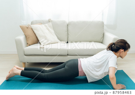 部屋で腕立て伏せをするミドル世代の女性 87958463