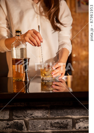 カウンターでお酒をつくる女性　BAR 87961953