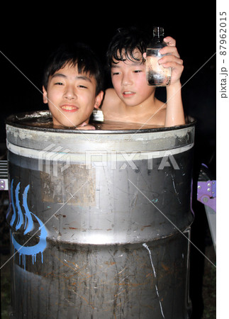 コロナ禍で外出を控え、自宅駐車場でドラム缶風呂を楽しんでいる子供 87962015