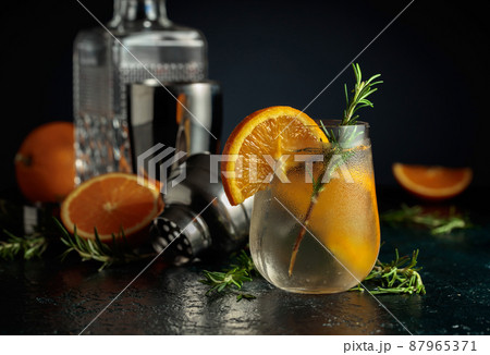 Cocktail gin tonic with ice, orange, and rosemary. Cocktail gin tonic with ice, orange, and rosemary. 87965371