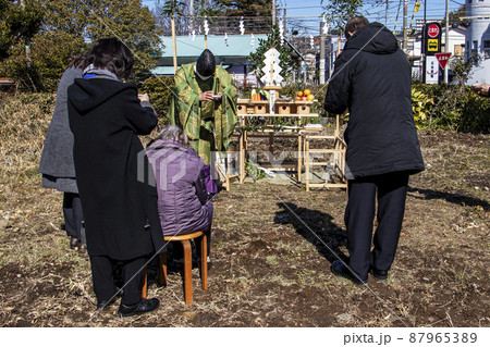 地鎮祭で建築工事の安全を祈願し祭壇の前で祈りを捧げる神主と施主 87965389