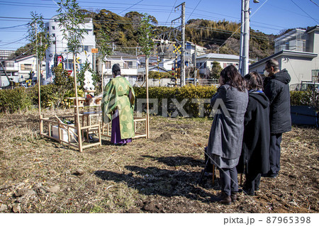地鎮祭で建築工事の安全を祈願し祭壇の前で祈りを捧げる神主と施主 87965398
