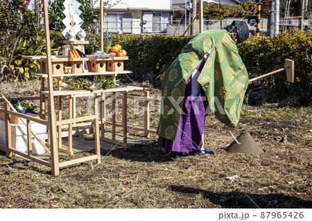 地鎮祭で建築工事の安全を祈願し盛り砂に鍬入れの儀を行う神主 地鎮祭で建築工事の安全を祈願し盛り砂に鍬入れの儀を行う神主 87965426