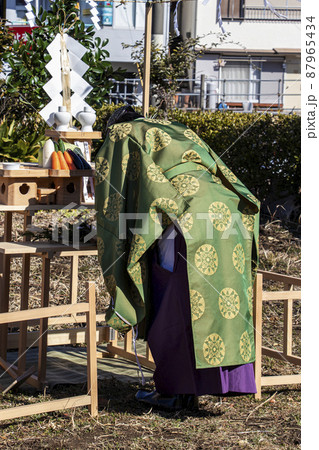 地鎮祭で祭壇に向かい建築工事の安全祈願を祈祷する神主 87965434