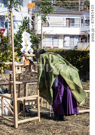 地鎮祭で祭壇に向かい建築工事の安全祈願を祈祷する神主 地鎮祭で祭壇に向かい建築工事の安全祈願を祈祷する神主 87965435