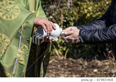 地鎮祭で建築工事の安全祈願を祈祷し施主に神酒拝戴を行う神主 地鎮祭で建築工事の安全祈願を祈祷し施主に神酒拝戴を行う神主 87965468