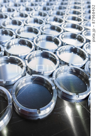 shiny metal rings after turning and milling, silver colored parts on flat steel surface close-up full frame background 87968402