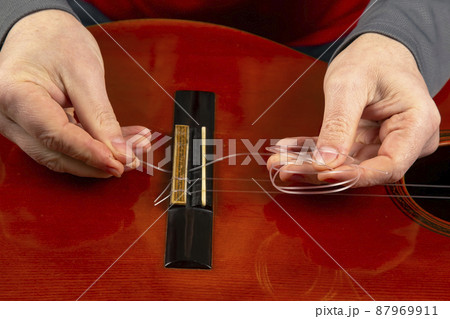 replacement and insertion of nylon strings in a classical guitar. lesson for a musician 87969911