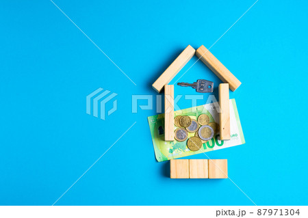 Wooden toy house with keys on blue. Empty space to put text or something else. Wooden toy house with keys on blue. Empty space to put text or something else. 87971304