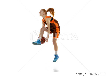Portrait of young active girl, basketball player training, dribblig ball in a jump isolated over white studio background. Portrait of young active girl, basketball player training, dribblig ball in a jump isolated over white studio background. 87972398