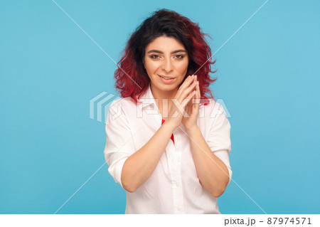 Distrustful sneaky hipster woman with fancy red hair in white shirt thinking cunning idea to prank friend, having tricky plan in mind, scheming revenge. indoor studio shot isolated on blue background Distrustful sneaky hipster woman with fancy red hair in white shirt thinking cunning idea to prank friend, having tricky plan in mind, scheming revenge. indoor studio shot isolated on blue background 87974571