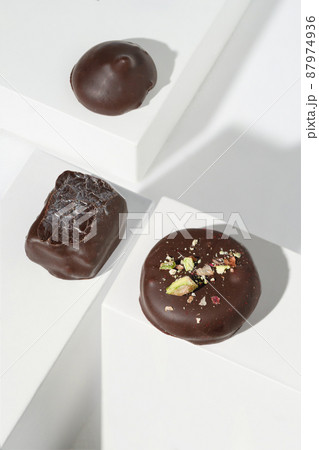 a set of handmade chocolates on a white background. Geometric minimalistic white background. Stylish image design a set of handmade chocolates on a white background. Geometric minimalistic white background. Stylish image design 87974936
