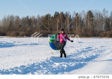 Fun Young woman snow tube in winter park. Leisure on nature, snow slide skiing. Concept of interactive entertainment. Fun Young woman snow tube in winter park. Leisure on nature, snow slide skiing. Concept of interactive entertainment. 87975038