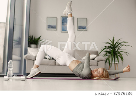 Girl in a sports uniform make yoga at home Girl in a sports uniform make yoga at home 87976236