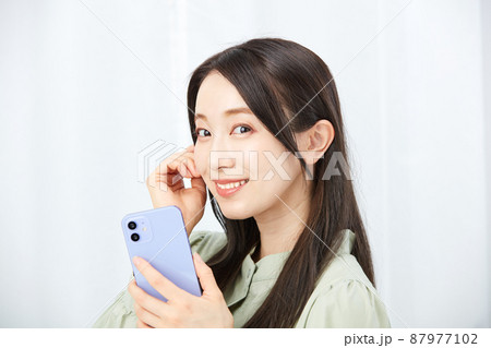 スマホを持つ女性 87977102