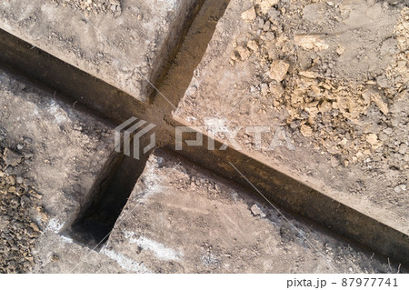 Dug out trench for building works of new house concrete foundation on construction site Dug out trench for building works of new house concrete foundation on construction site 87977741