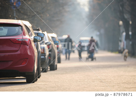 City traffic with cars parked in line on street side 87978671
