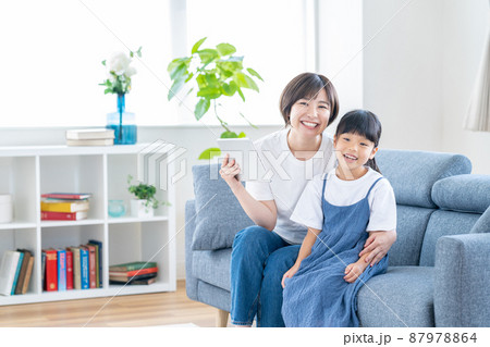 ソファーに座ってタブレットで動画を見る親子 ソファーに座ってタブレットで動画を見る親子 87978864