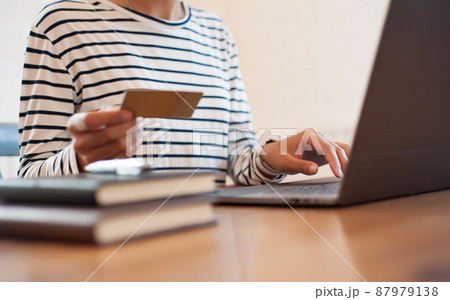 Woman holding credit card while using top. Online shopping concept. Woman holding credit card while using top. Online shopping concept. 87979138