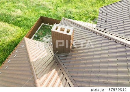 Aerial view of house roof structure covered with brown metal tile sheets. 87979312