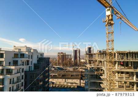 Aerial view of high tower crane and residential apartment buildings under construction. Real estate development. 87979313