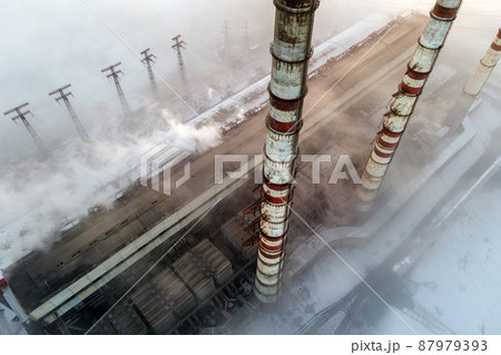 Aerial view of coal power plant high pipes with black smoke moving up polluting atmosphere at sunset. 87979393