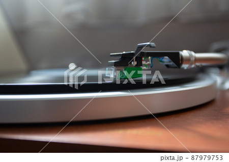 レコード盤の溝をトレースするレコード針を真横から撮影したクローズアップ写真 87979753