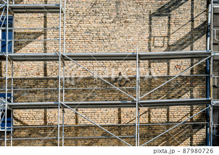 Reconstruction of an old brick house. Scaffolding for construction, construction site. Selective focus Reconstruction of an old brick house. Scaffolding for construction, construction site. Selective focus 87980726