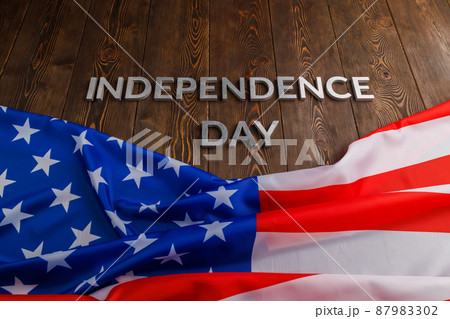 the words independence day laid on brown wooden planks surface with crumpled united states of america flag the words independence day laid on brown wooden planks surface with crumpled united states of america flag 87983302