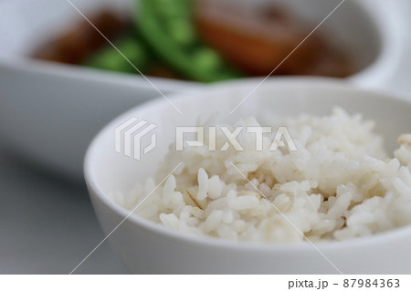 お茶碗に盛った押し麦入りの金芽米ご飯とおかず 87984363