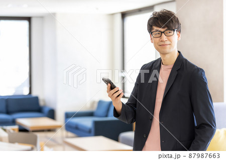 コワーキングスペースでスマホを操作するビジネスマン コワーキングスペースでスマホを操作するビジネスマン 87987663